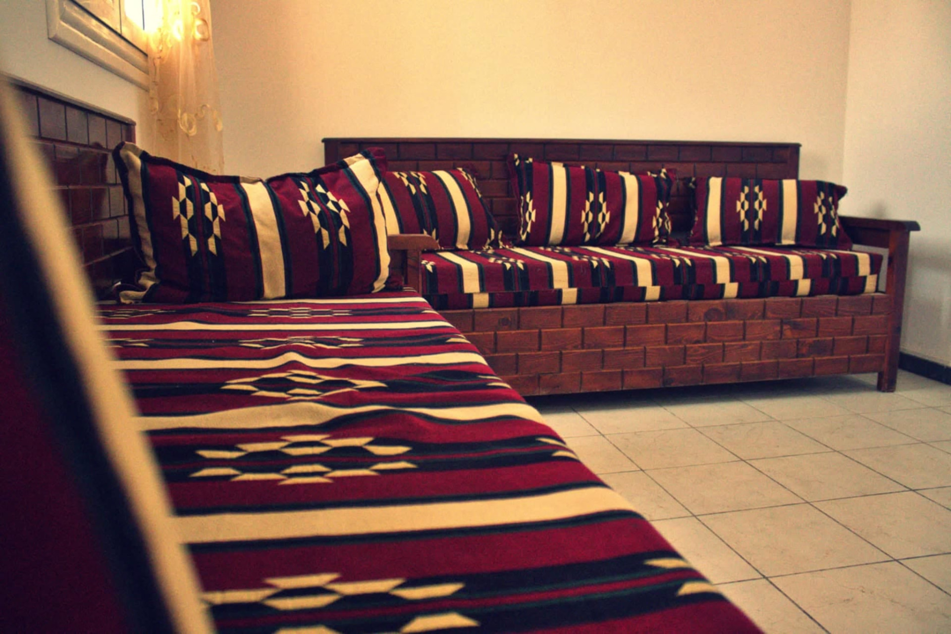 Salon avec banquettes traditionnelles et tissus berbères